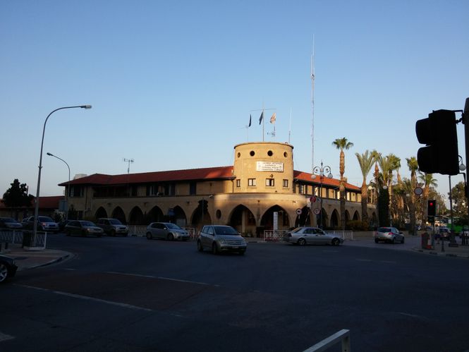 historic government building with a tower at a busy intersection in Larnaca