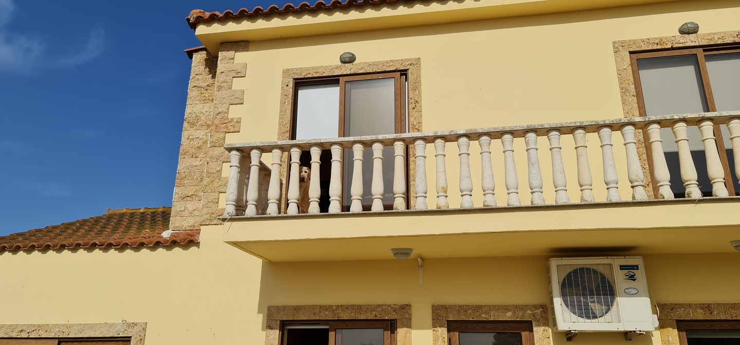 Cypriot house with stone facade and traditional balcony with railing