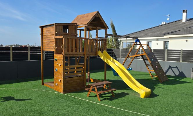 wooden playground with a slide in the garden of a Cypriot home