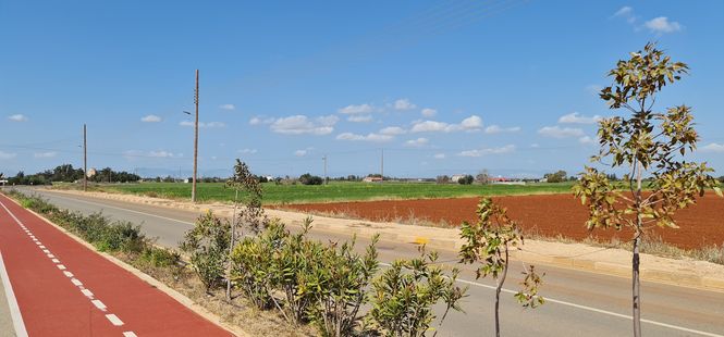 Cypriot village road with red earth and a bicycle path