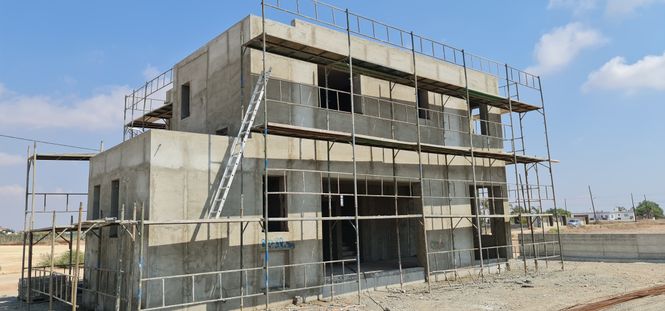 house in shell state with scaffolding at a Cypriot construction site
