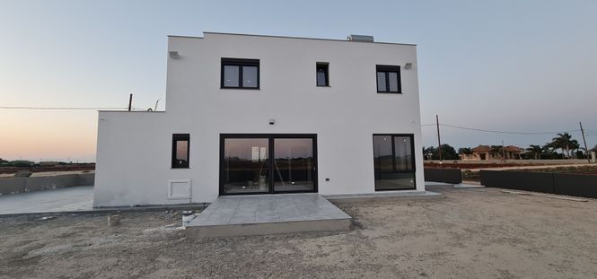 newly built white house with large windows on a Cypriot plot