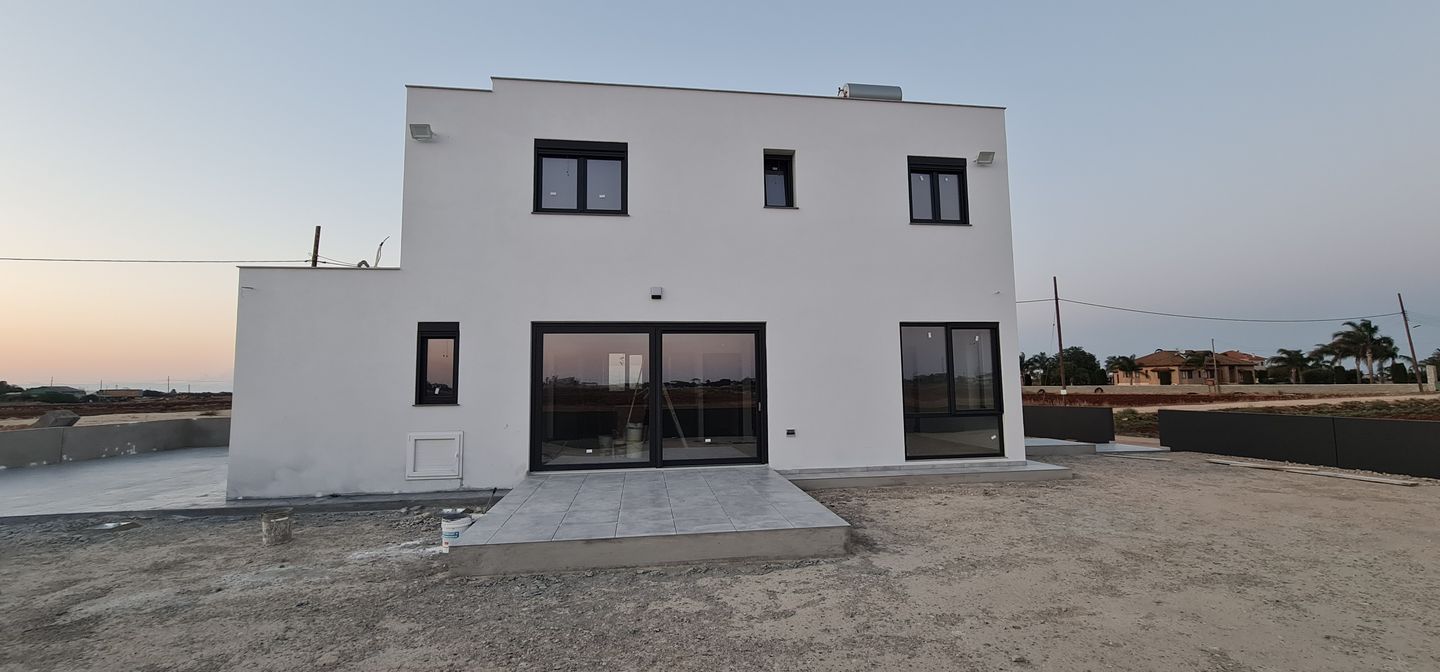 newly built white house with large windows on a Cypriot plot