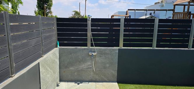 simple outdoor shower mounted on the wall of a Cypriot stone house